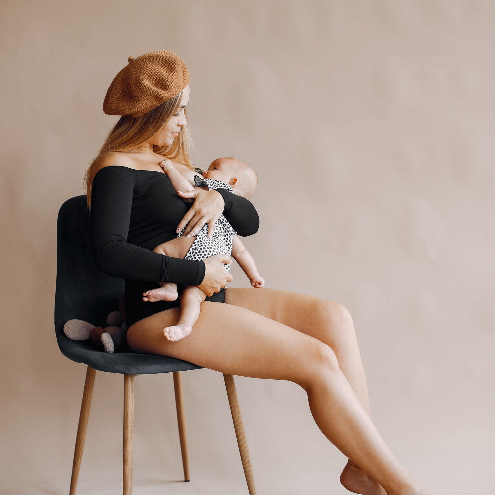 Mother with cute daughter. Blonde with long hair. Mom breastfeeding her little daughter